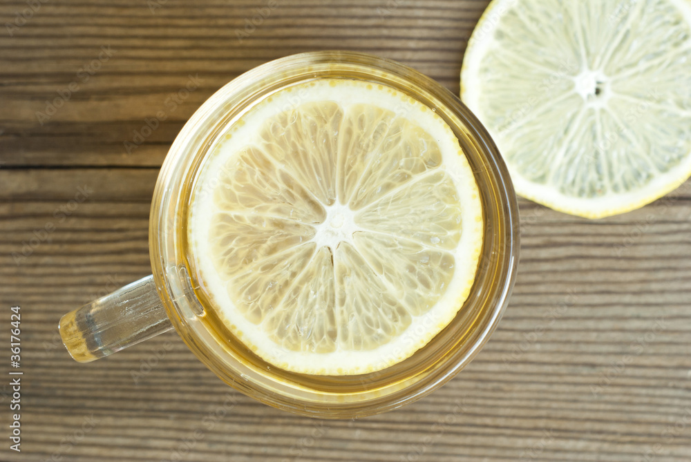 cup of tea and sliced lemon on wooden table, directly above cup of tea and sliced lemon on wooden table, directly above