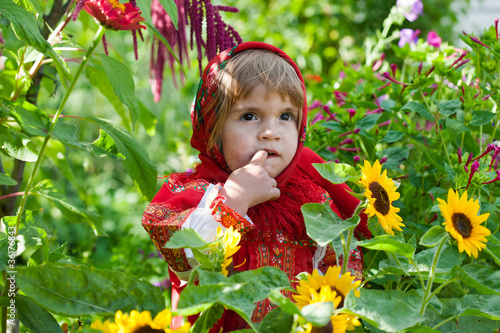 little girl in Russian national dress among sunflowers