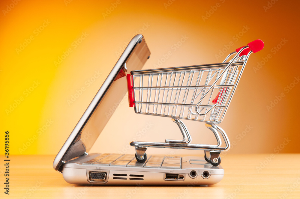 Shopping online with computer and cart Shopping online with computer and cart