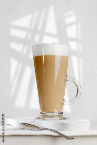 coffee latte with frothy milk in tall glass
