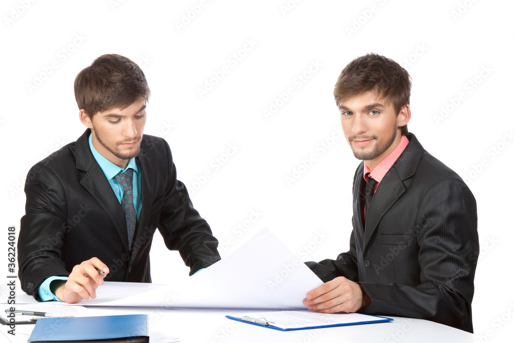 Two business people in elegant suits sitting at desk working Two business people in elegant suits sitting at desk working