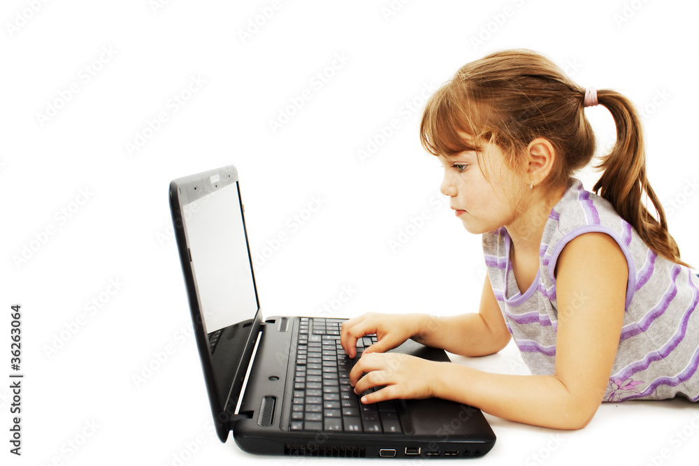Beautiful little girl lying on floor with a laptop Beautiful little girl lying on floor with a laptop