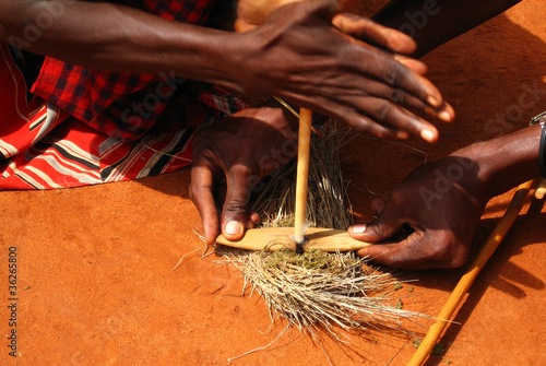 Two Masai light fire in traditional way photo