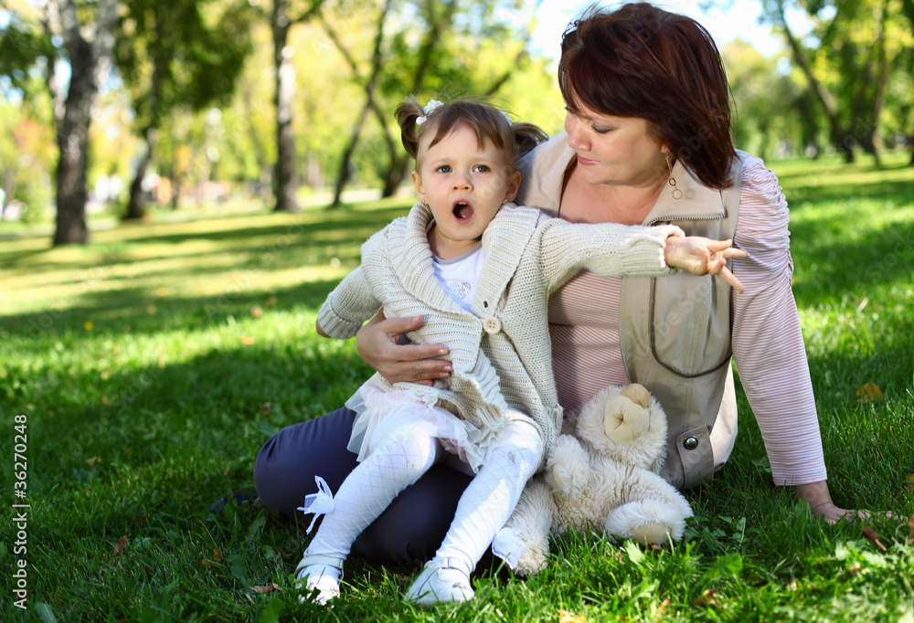 Fototapeta premium Grandmother with her little granddaghter in park
