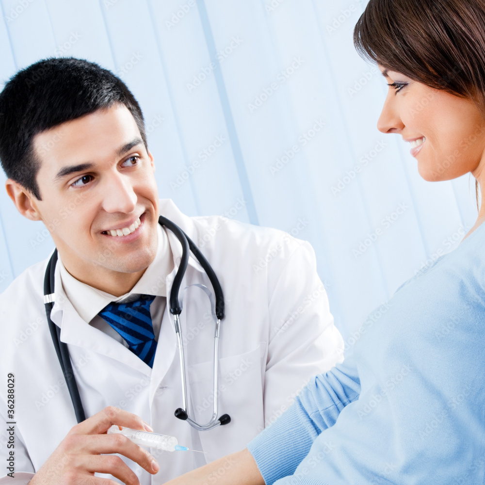 Happy doctor giving an injection to female patient Happy doctor giving an injection to female patient