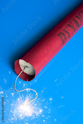 Naklejka Lit dynamite stick on a blue background