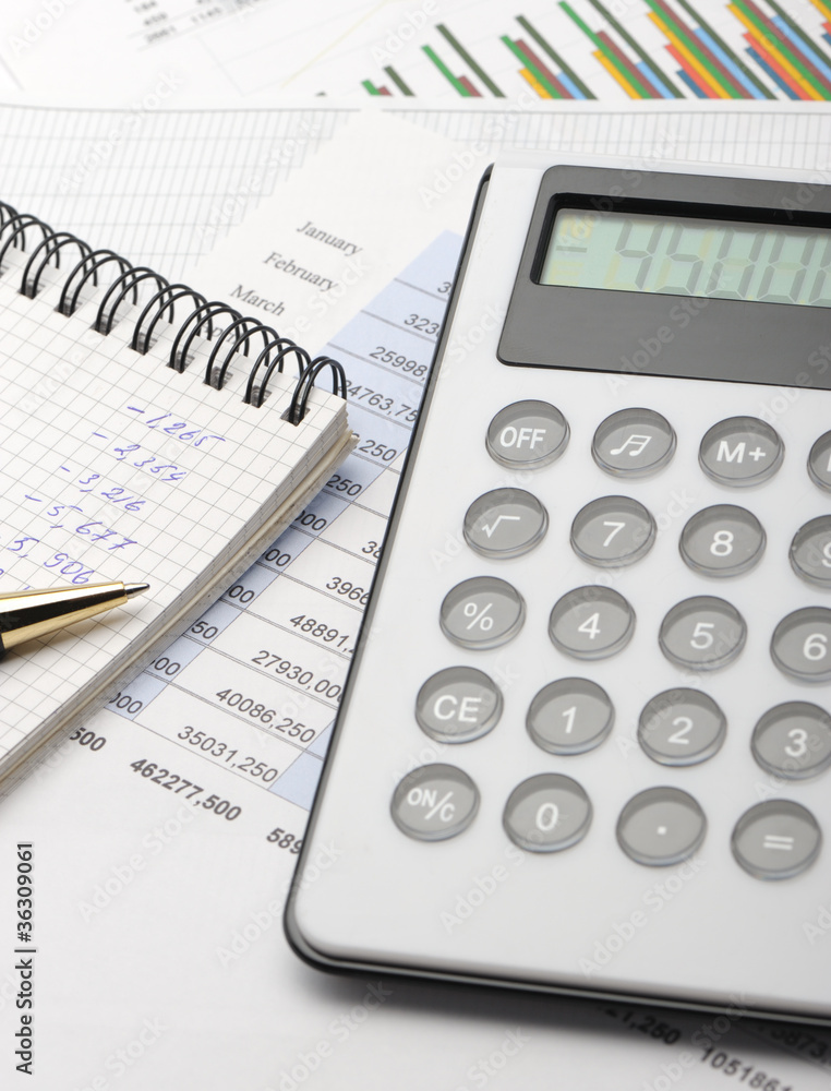 The calculator and the financial report blue toned The calculator and the financial report blue toned