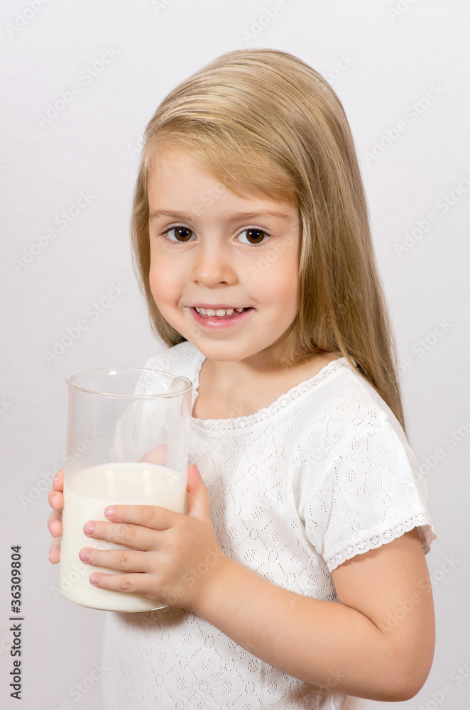 Cheerful girl holding a large glass of milk. Breakfast time. Cheerful girl holding a large glass of milk. Breakfast time.