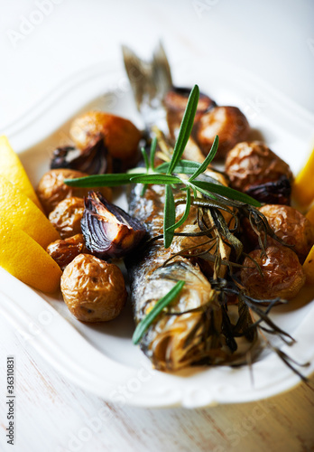 Rustic oven baked fish with potatoes, onions and rosemary