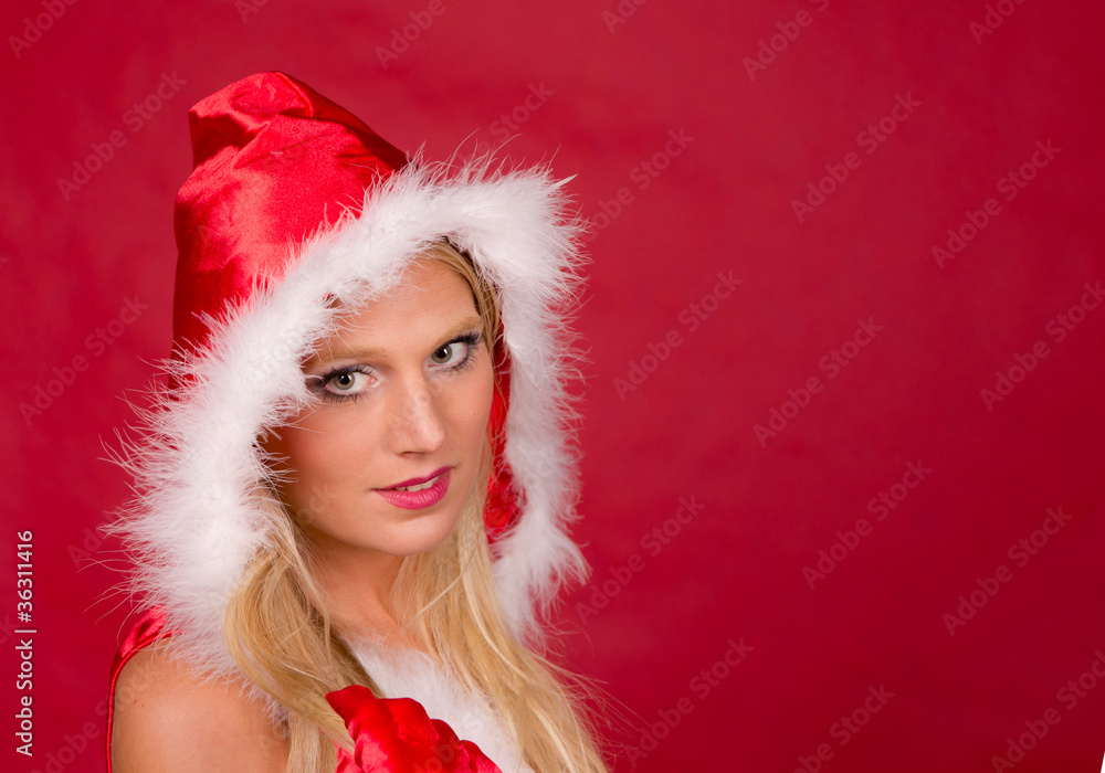 Beautiful blond girl in santa costume on red background Beautiful blond girl in santa costume on red background