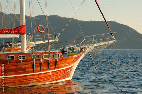 Traditional wooden Turkish gulet boat in Marmaris harbor at sunset, Turkey.