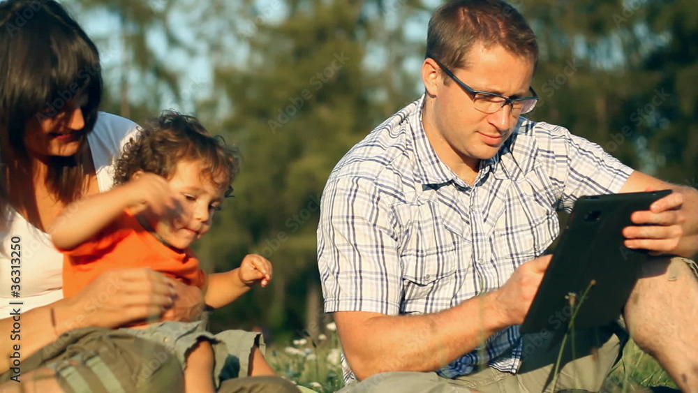 Happy family with tablet computer in the park Happy family with tablet computer in the park