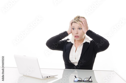 Junge Geschäftsfrau am Laptop ist entsetzt