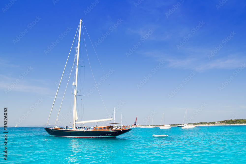 anchored sailboats in turquoise Formentera beach