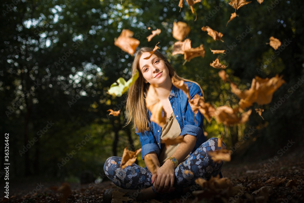 Beautiful young girl with falling leaves in the autumn park Beautiful young girl with falling leaves in the autumn park