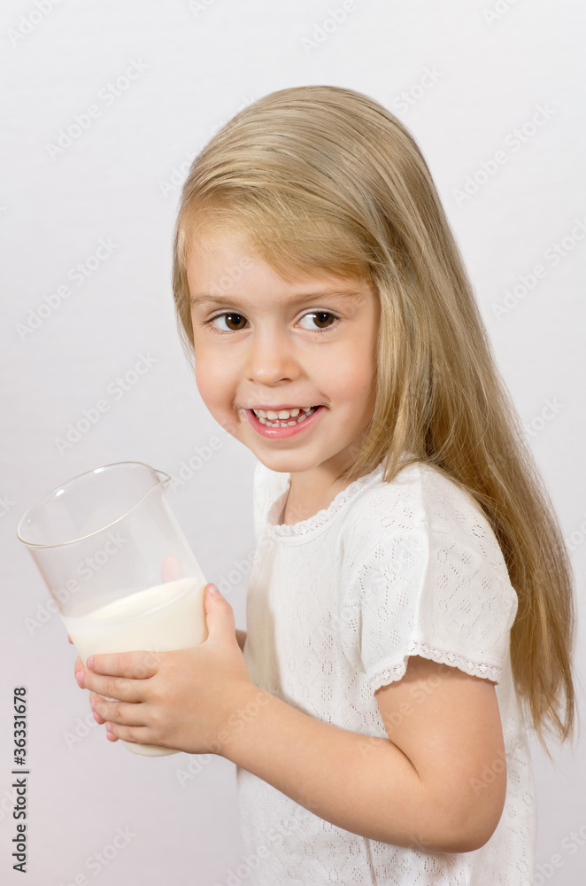 Cheerful girl holding a large glass of milk. Breakfast time. Cheerful girl holding a large glass of milk. Breakfast time.