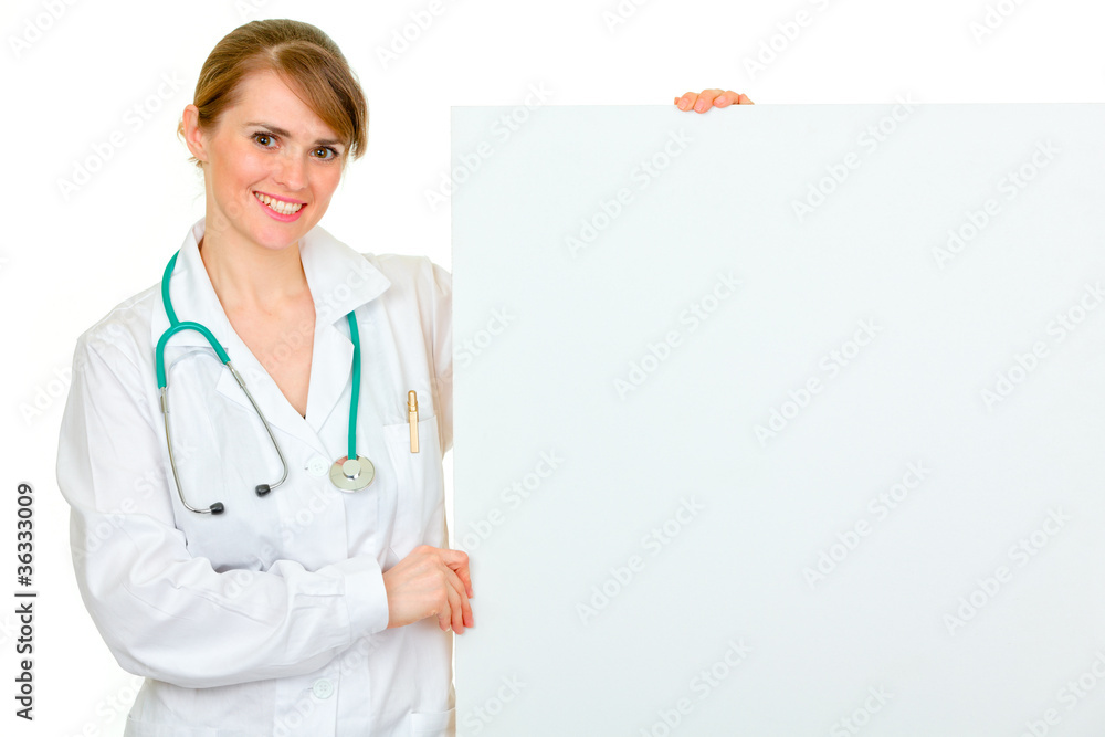 Smiling medical female doctor holding blank billboard Smiling medical female doctor holding blank billboard