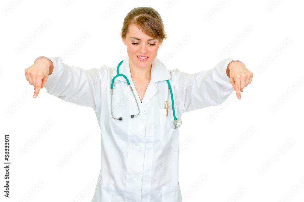 Medical doctor woman pointing down Medical doctor woman pointing down