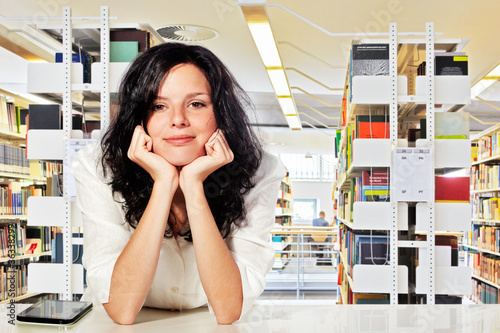 pretty female student with tablett-pc in the library