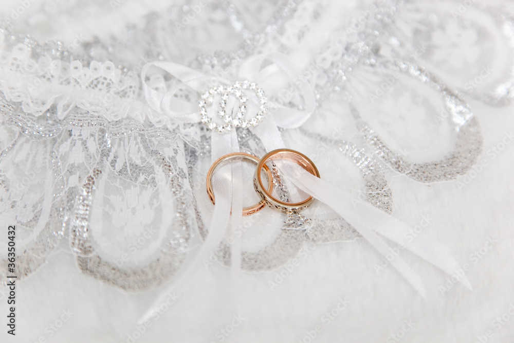 Two wedding rigns on white garter Two wedding rigns on white garter