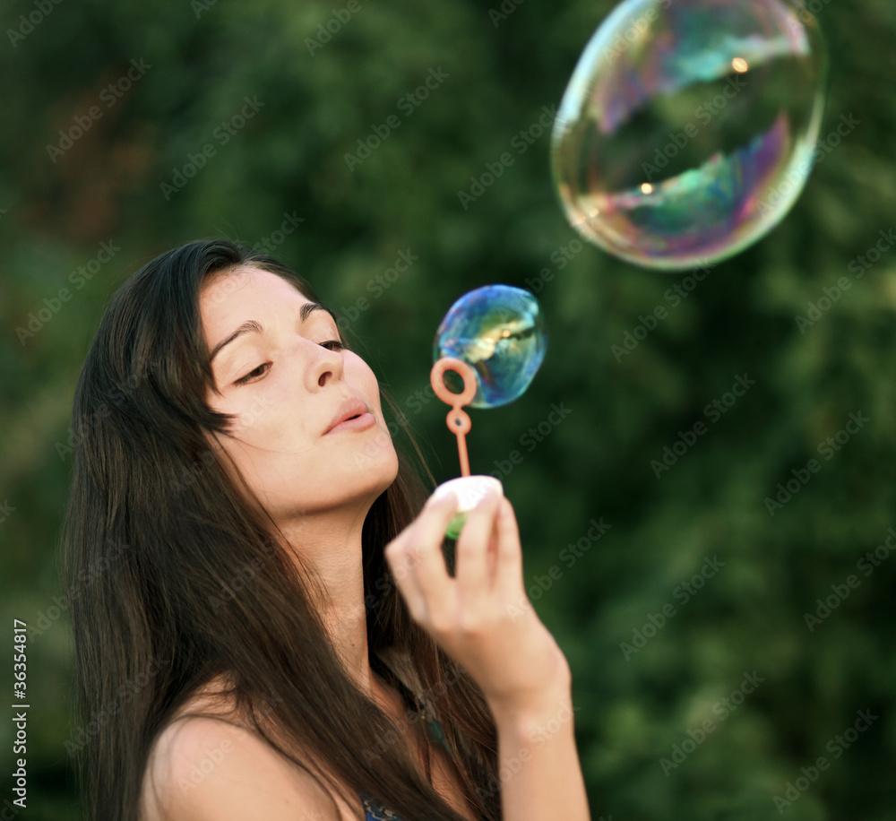 Pretty woman inflating soap-bubbles Pretty woman inflating soap-bubbles