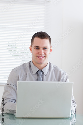 Close up of smiling businessman working on his laptop