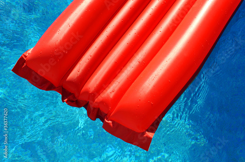 Colchoneta roja en piscina azul photo