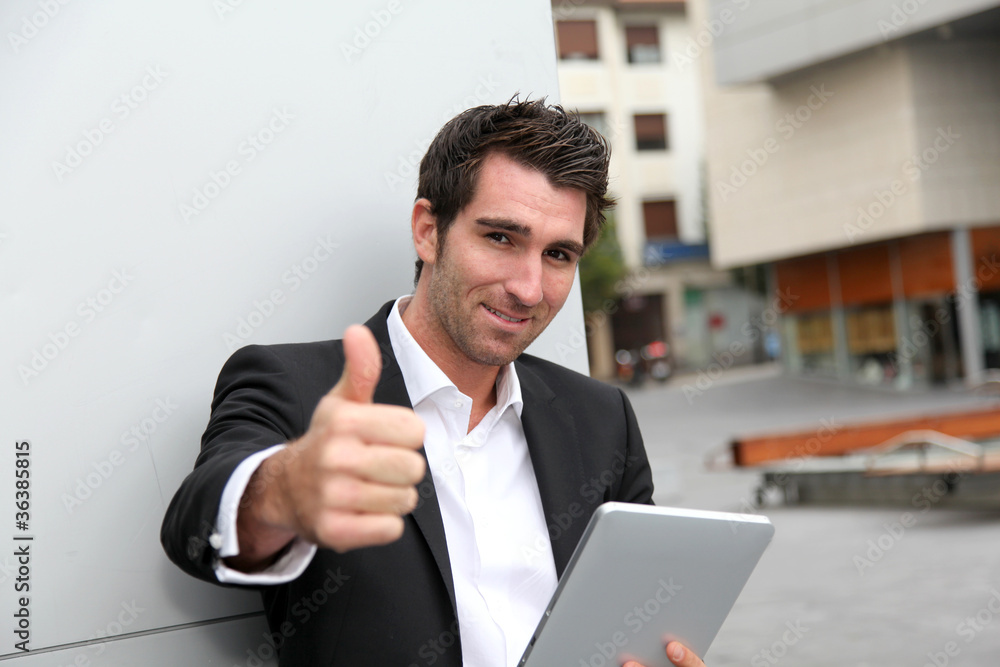 Man connected on internet with electronic tablet in town Man connected on internet with electronic tablet in town