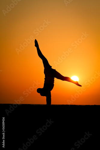 silhouette of gymnast at beach