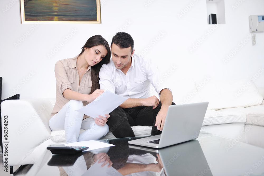 joyful couple relax and work on laptop computer at modern home joyful couple relax and work on laptop computer at modern home