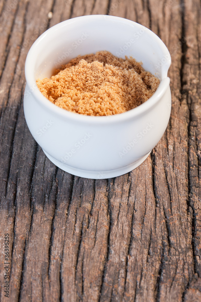 small cup of brown sugar on wood teak small cup of brown sugar on wood teak