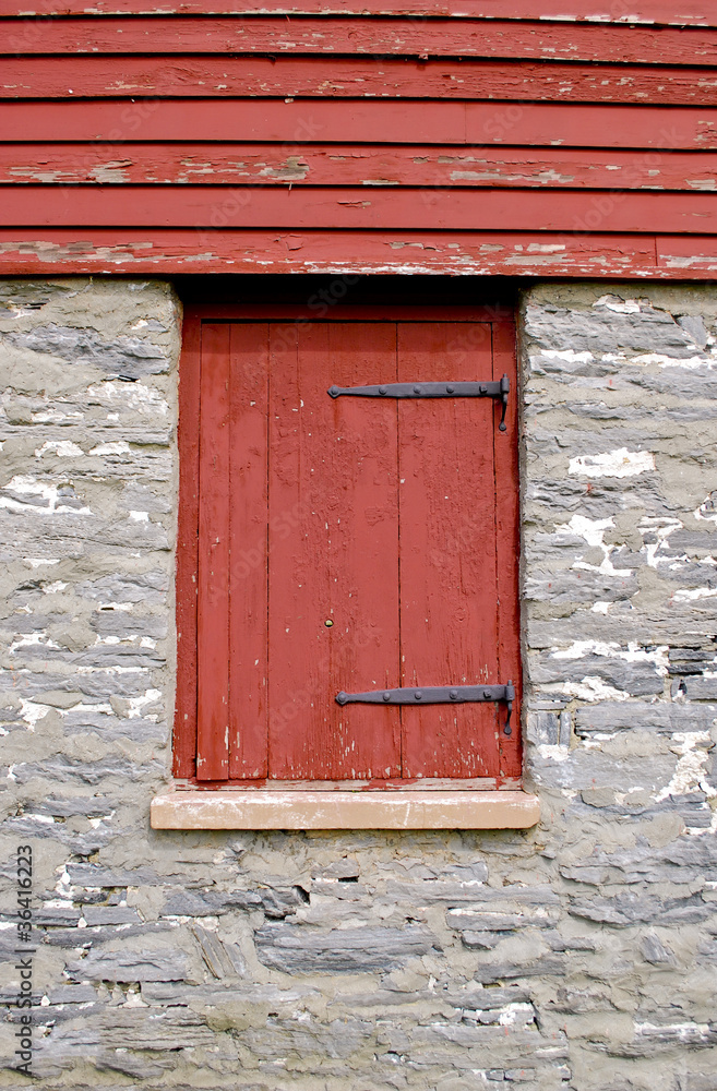 Red shutter on beautiful stone building