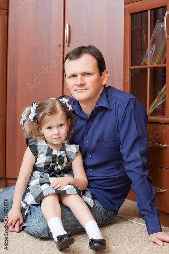 Konstfotografi father with a daughter sit in a room on a floor