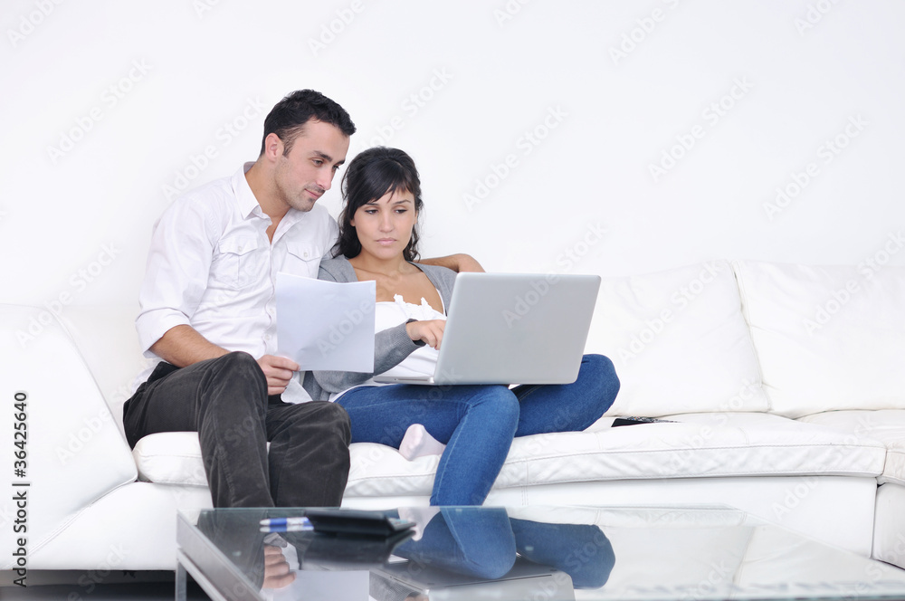 joyful couple relax and work on laptop computer at modern home joyful couple relax and work on laptop computer at modern home