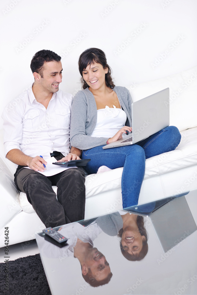joyful couple relax and work on laptop computer at modern home joyful couple relax and work on laptop computer at modern home