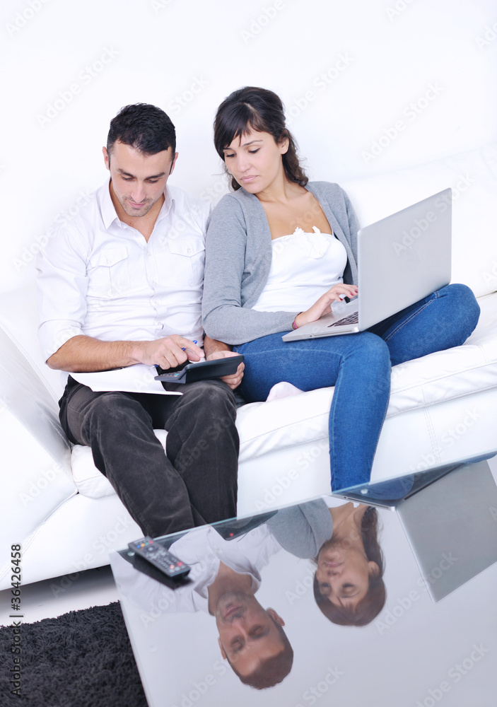 joyful couple relax and work on laptop computer at modern home joyful couple relax and work on laptop computer at modern home