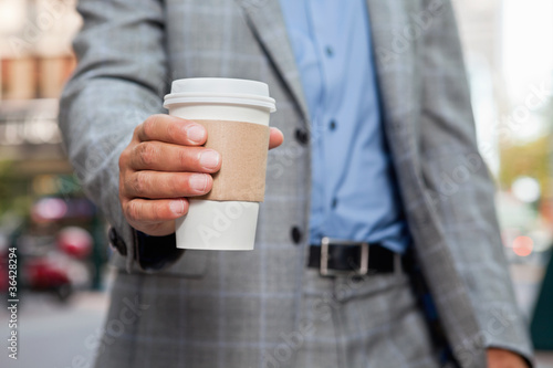 Businessman holding disposable cup