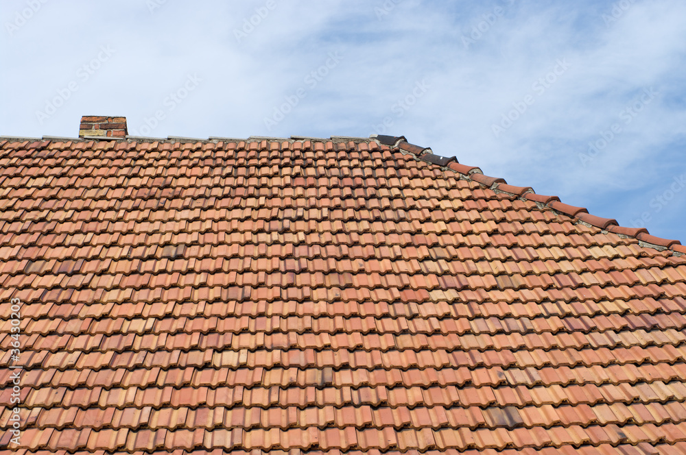 The roof of tiles and chimney against the sky. The roof of tiles and chimney against the sky.