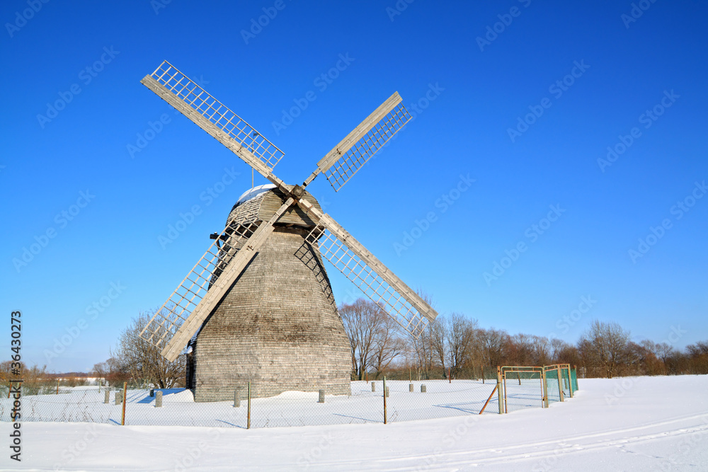 aging wind mill on winter field
