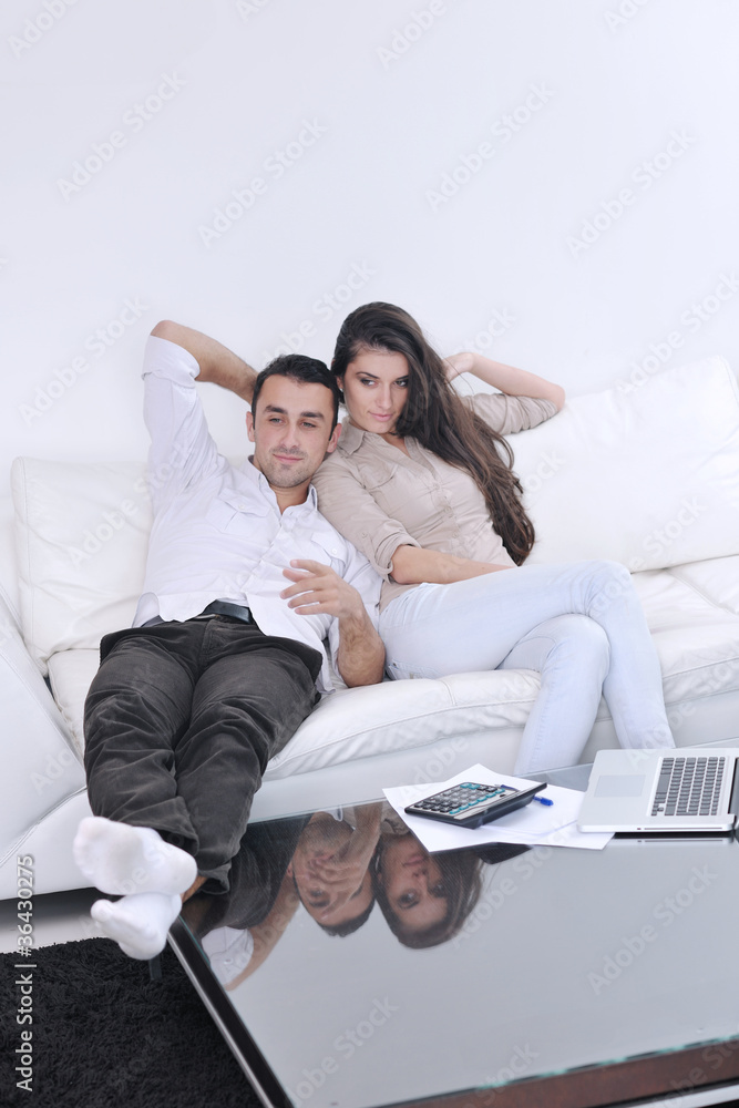joyful couple relax and work on laptop computer at modern home joyful couple relax and work on laptop computer at modern home
