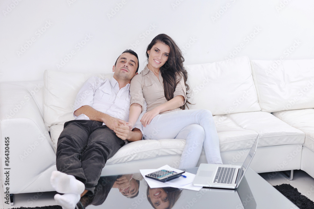 joyful couple relax and work on laptop computer at modern home joyful couple relax and work on laptop computer at modern home