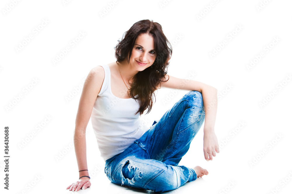 pretty woman in blue jeans sitting on white floor pretty woman in blue jeans sitting on white floor