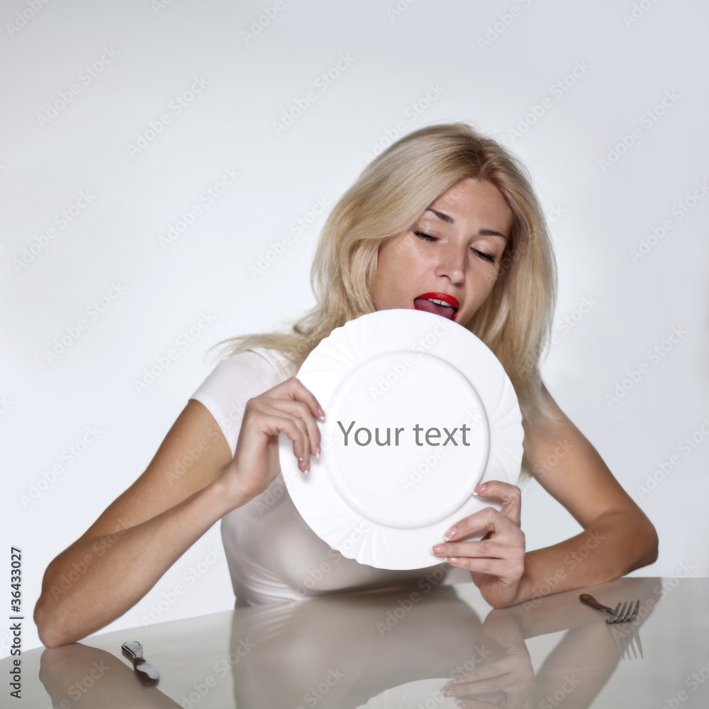 Blond woman licking plate. Copy space Stock Photo | Adobe Stock