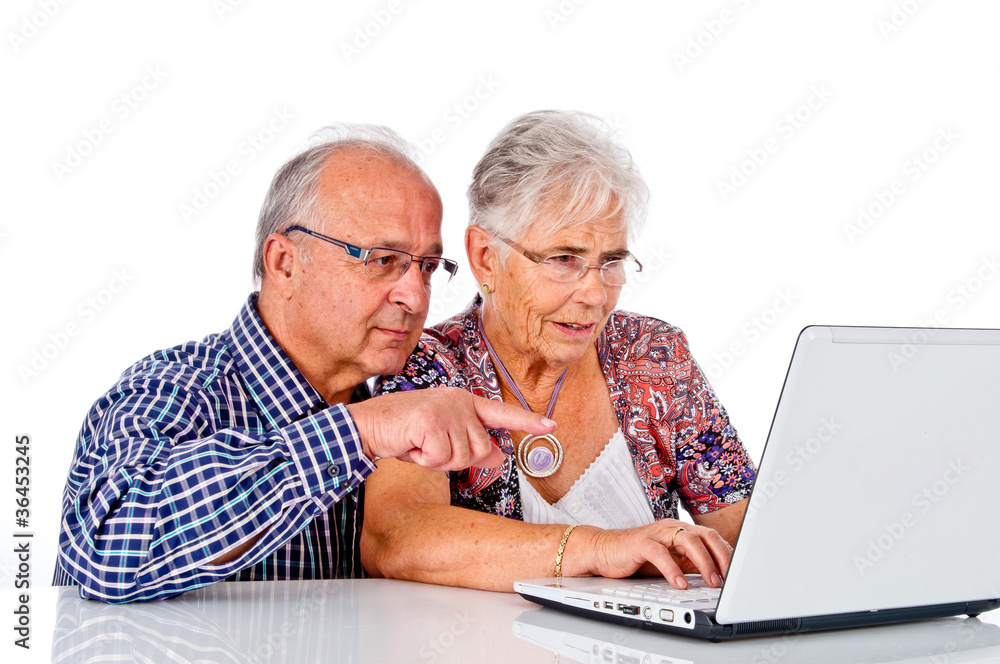 Senior man and woman using a computer laptop Senior man and woman using a computer laptop