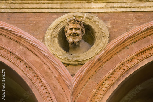 Tableau sur toile The devil's head decoration on medieval building in Bologna