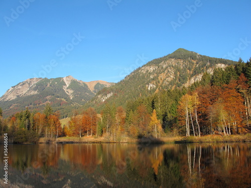 Herbstfarben im Gebirge spiegeln in See