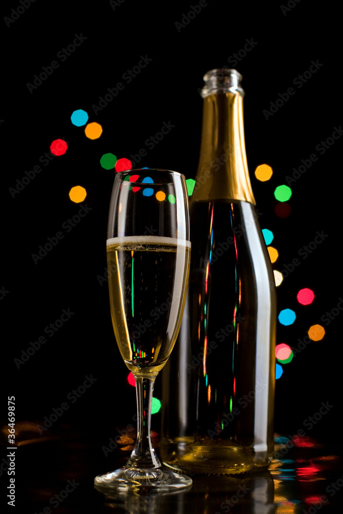 Champagne glasses and bottle on bokeh background. New Year celeb