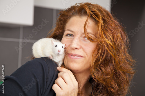 lächelnde Tierarzthelferin mit Ratte auf Schulter photo