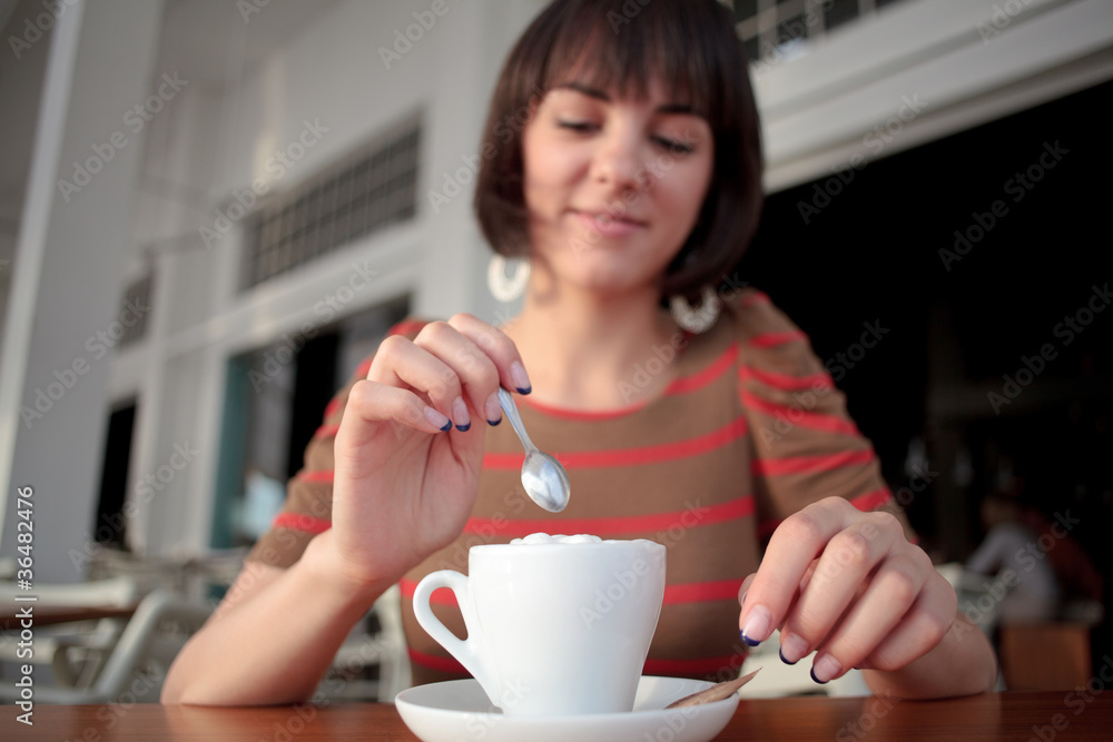 young woman stirring coffee young woman stirring coffee