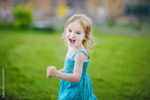 Adorable little girl laughing outdoors